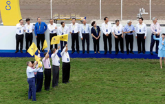 Officiating guests raise commemorative flags to start the horse jump-out as a highlight of the opening ceremony.